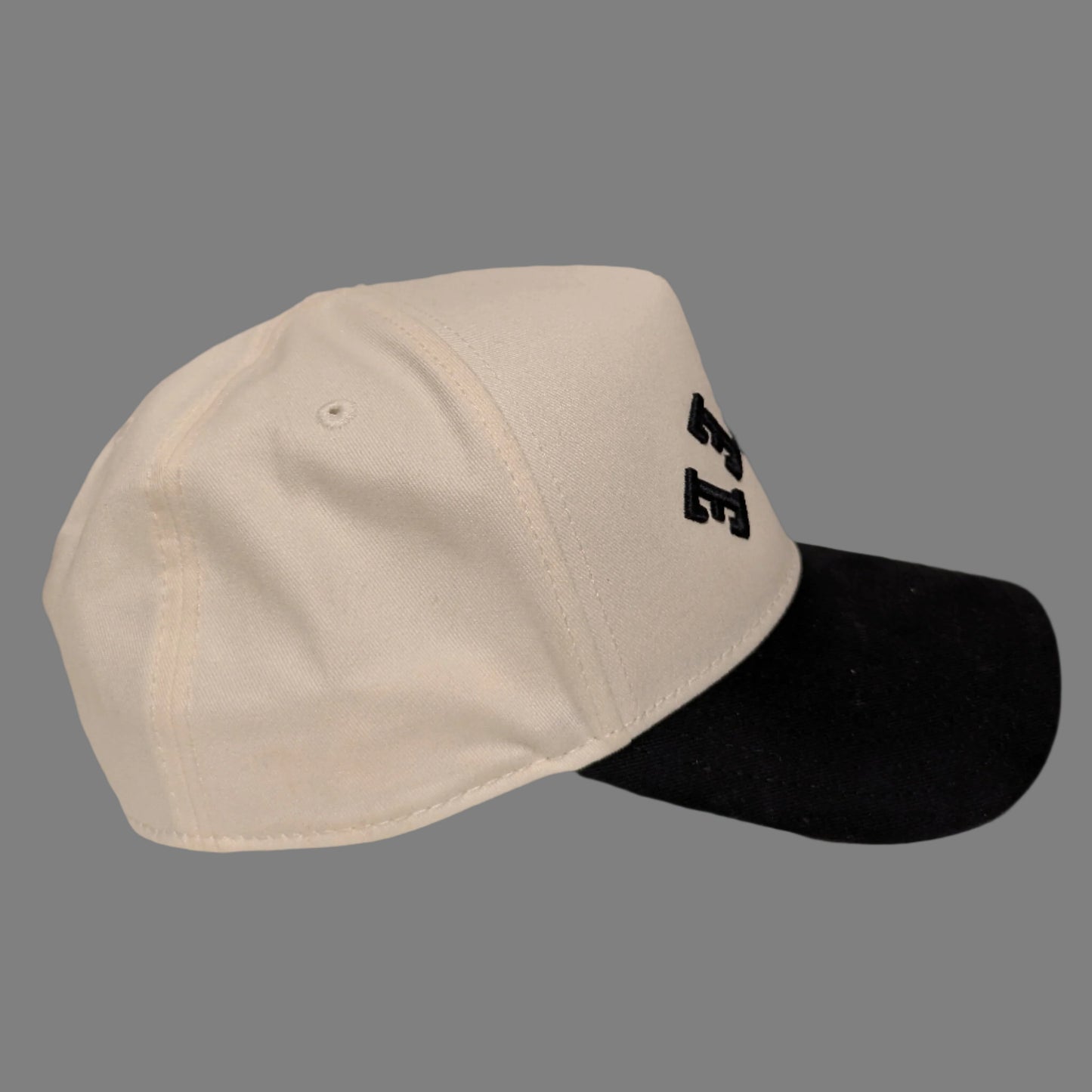 Two-tone cap with white front and black back on a beige background